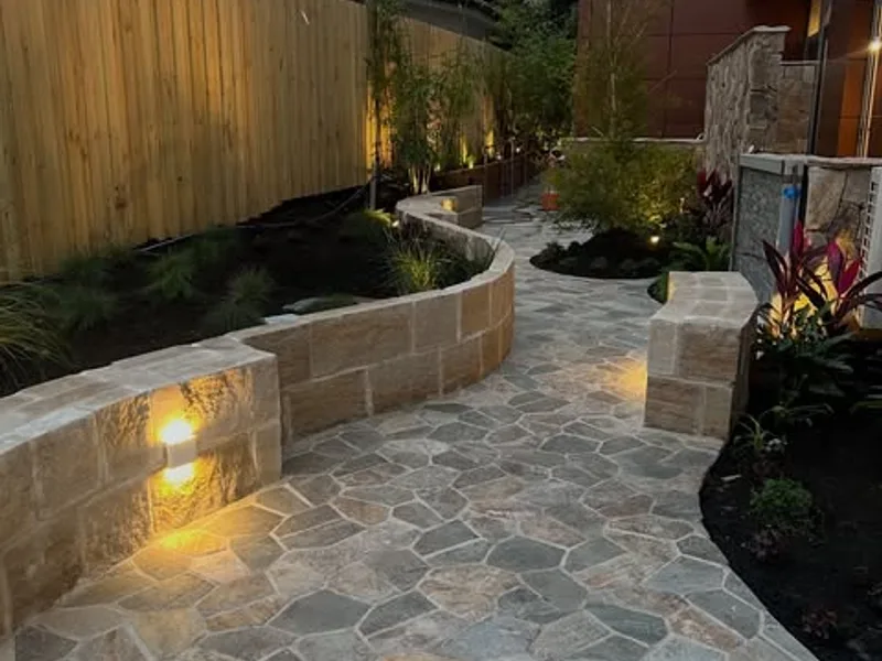Garden path at dusk lit by step lights in a sandstone wall