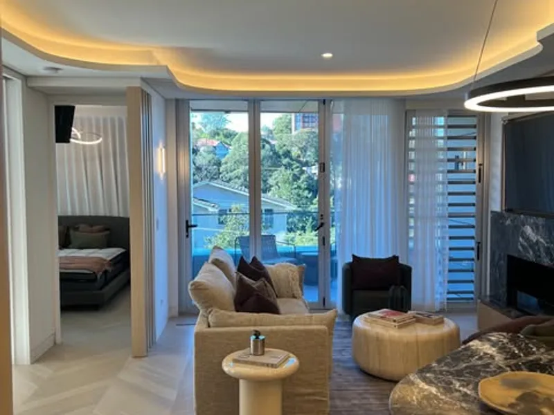 Living room with warm LED cove lighting, downlights and a ring pendant